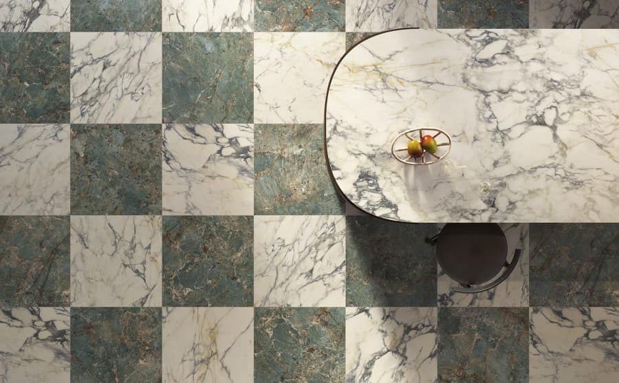 Pavimento in marmo a scacchiera con tavolo rotondo, sedia e un piatto di frutta.