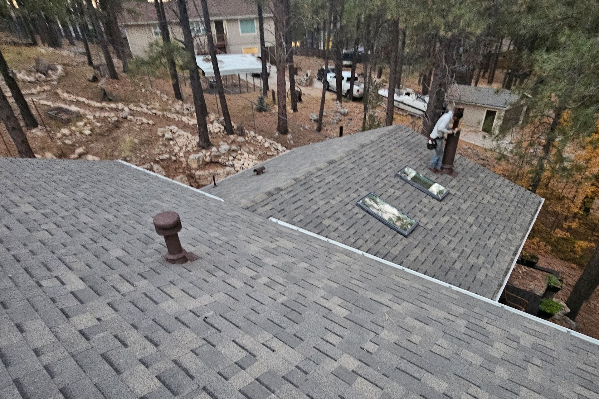 Man is Working on the Roof of a House in the Woods — Flagstaff, AZ — Northern Arizona Building and Investments