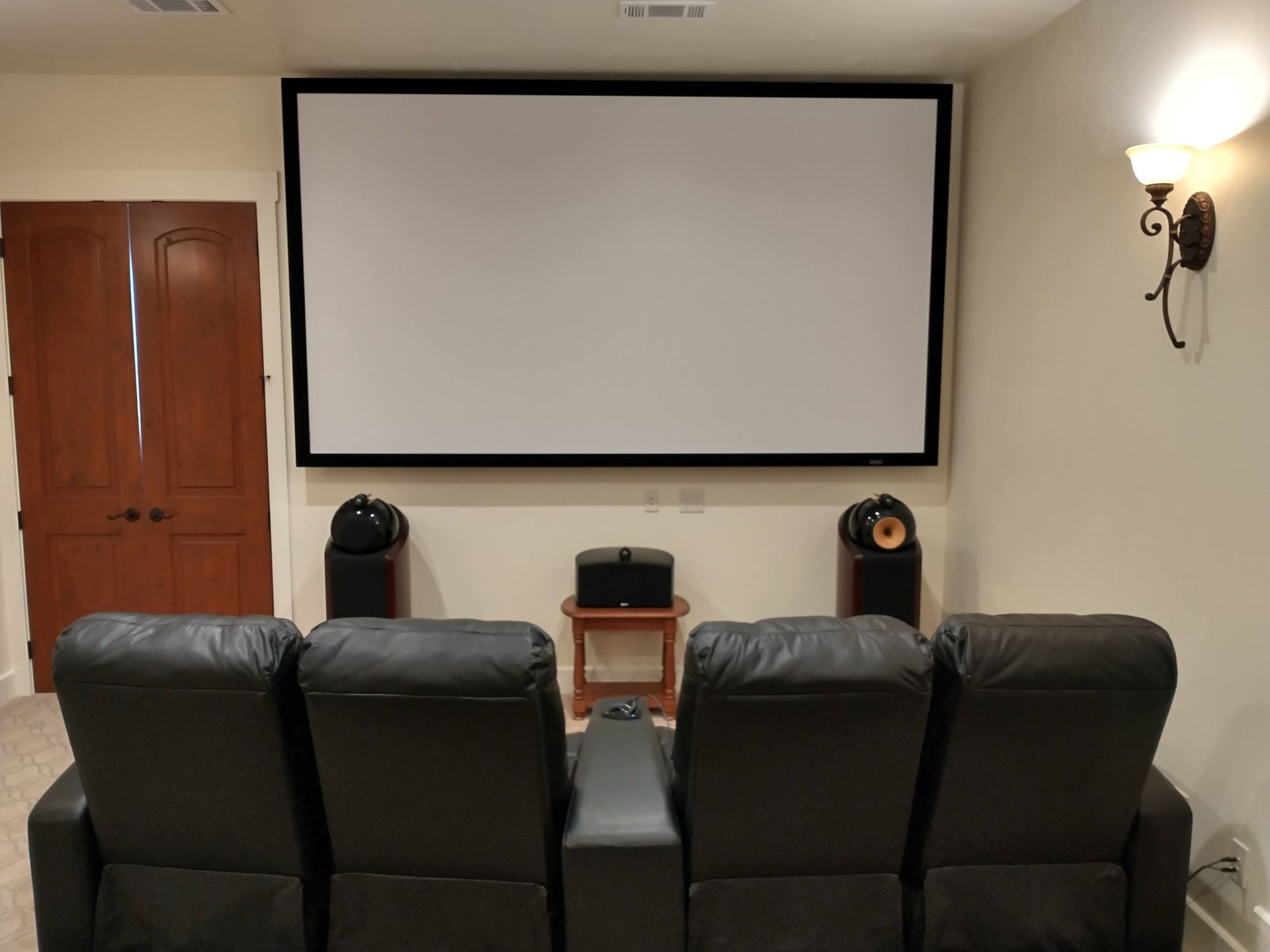 Home Theater With a Projector Screen and Black Leather Chairs — Austin, TX — ACA Electronics Inc.