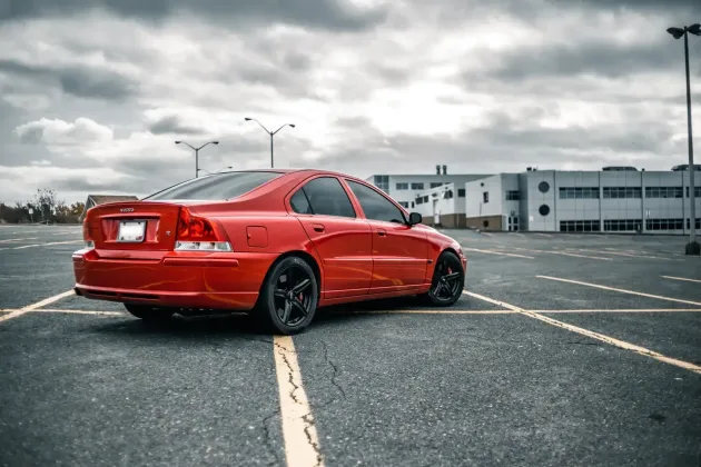 A red car is parked in a parking lot in front of a building | Berkeley Bob's