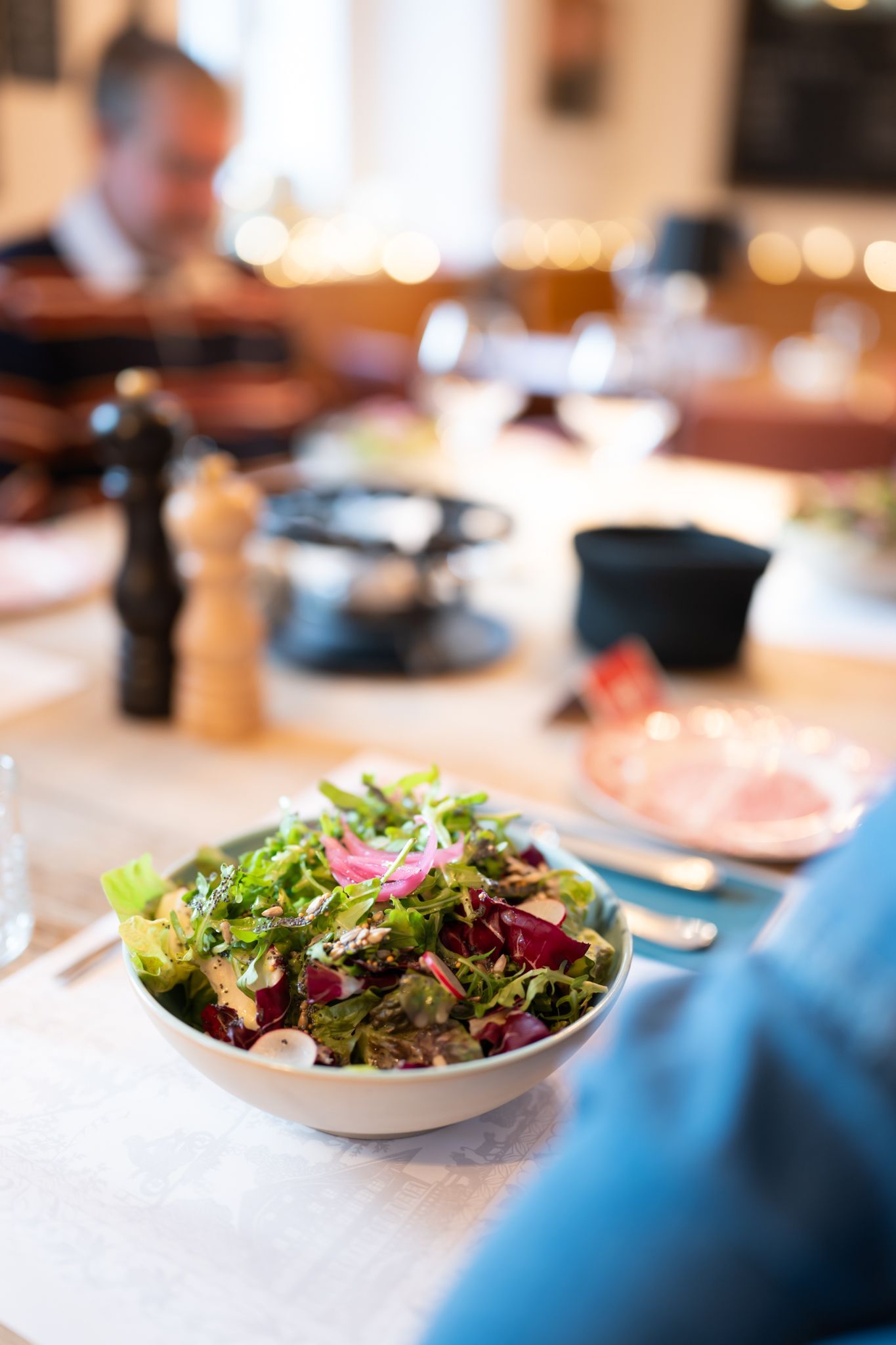 Saladier blanc de salades vertes mélangées avec petites graines et vinaigrette maison, Salade du Café, 
POSTE|ROPRAZ Ropraz