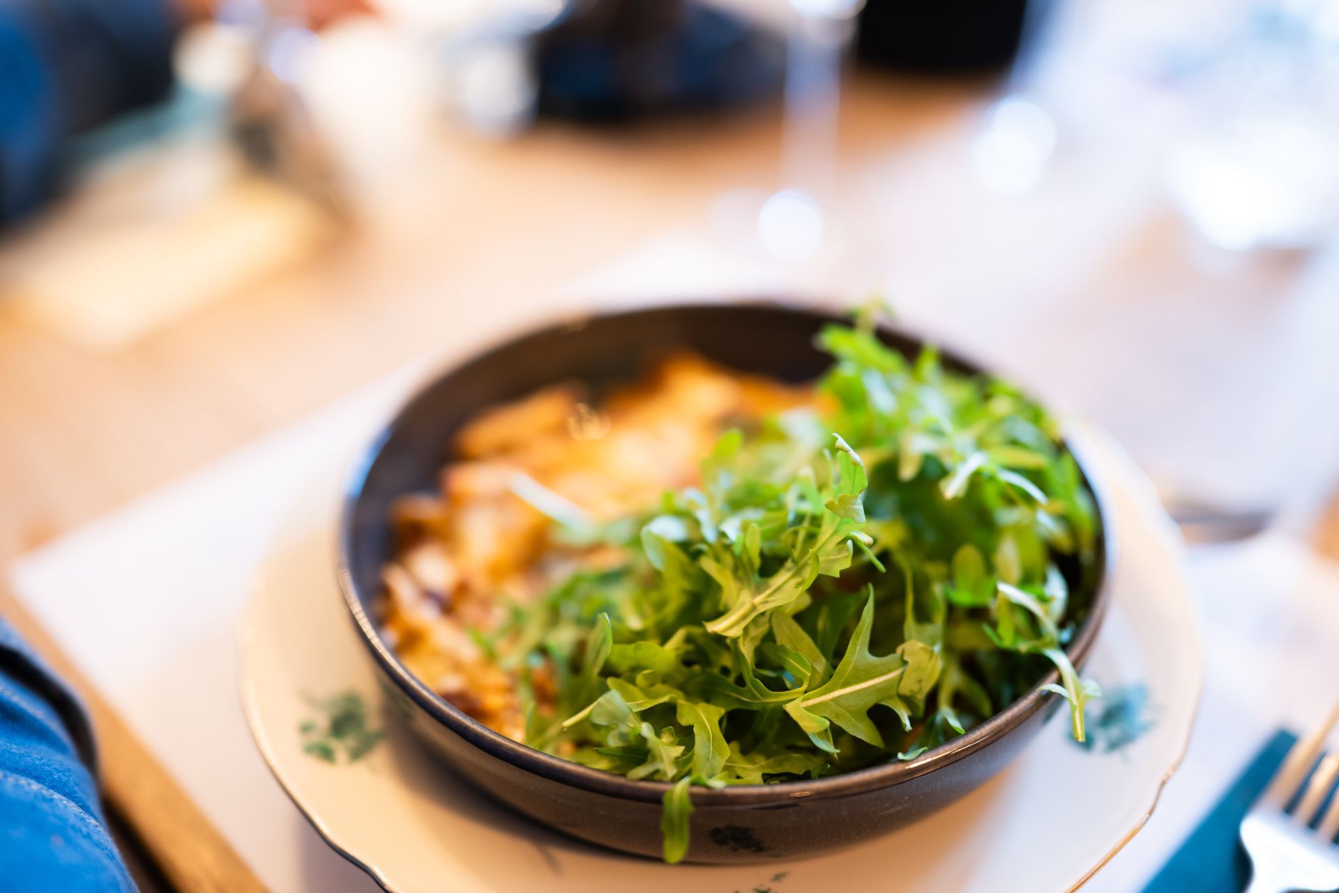 Gratin de pâtes au ragout de cerf servi dans un bo avec roquette sur le dessusl, POSTE|ROPRAZ Ropraz