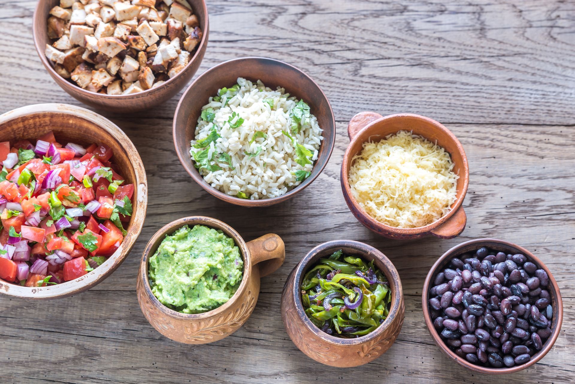 There are many different types of food in the bowls on the table.
