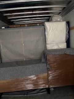 A person in casual clothes shakes hands with a delivery person holding a cardboard box in an office setting.