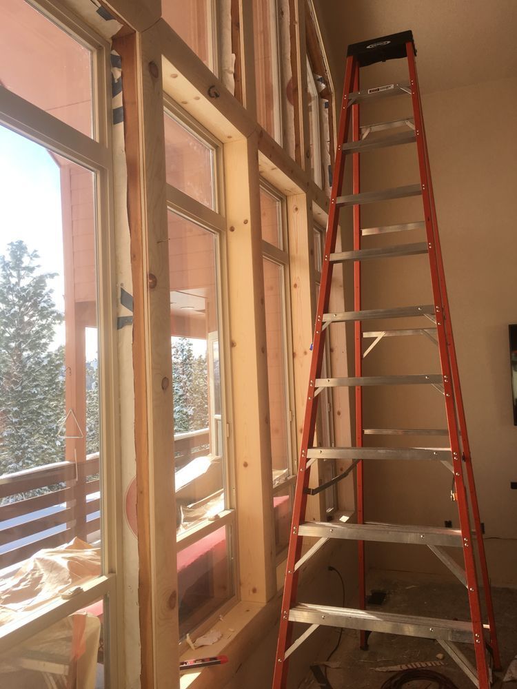 A ladder in a room with a lot of windows