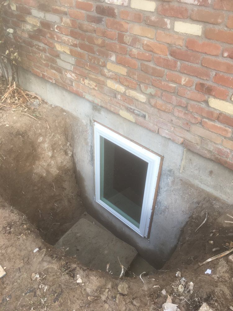 A window in the basement of a brick house.