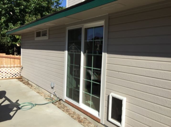 A house with a sliding glass door and a dog door.