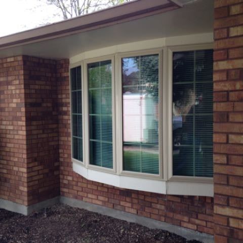 A brick house with a large bay window
