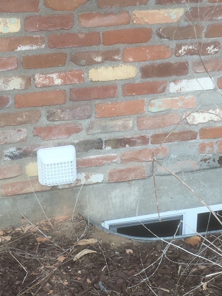 A brick wall with a white drain on it