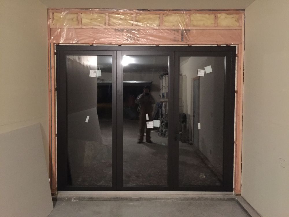 A man is standing in a room with sliding glass doors.