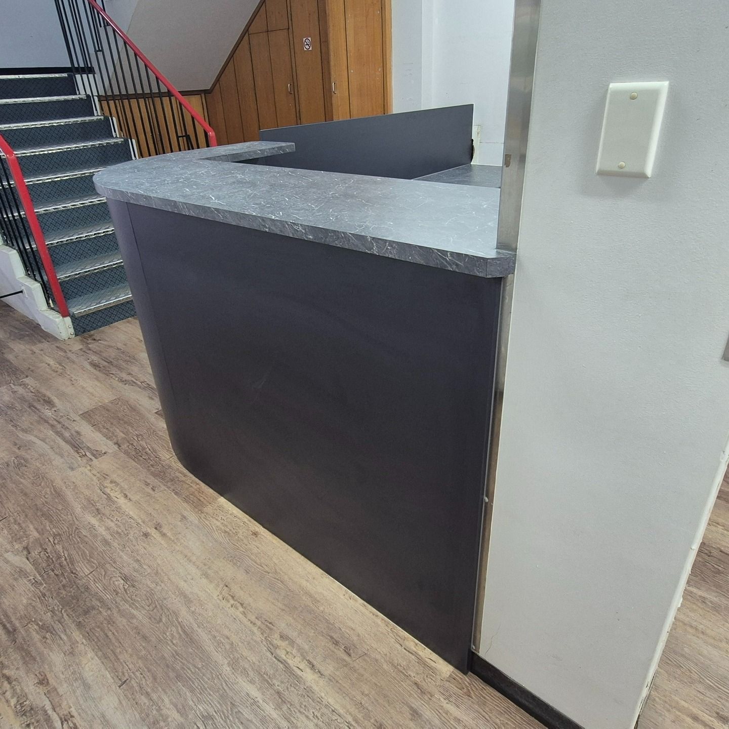 Dark Gray Reception Desk With Gray Countertop And Wooden Floor, Near A Staircase — B & C Cabinets in Mareeba, QLD