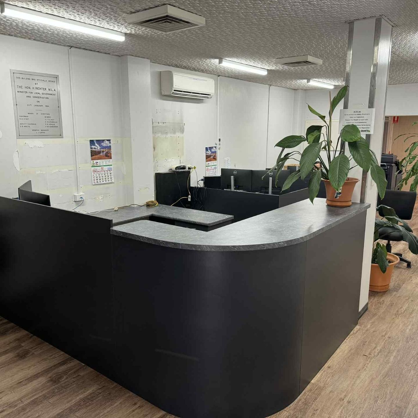 Black Reception Desk In Office, With Computers And Plants — B & C Cabinets in Mareeba, QLD