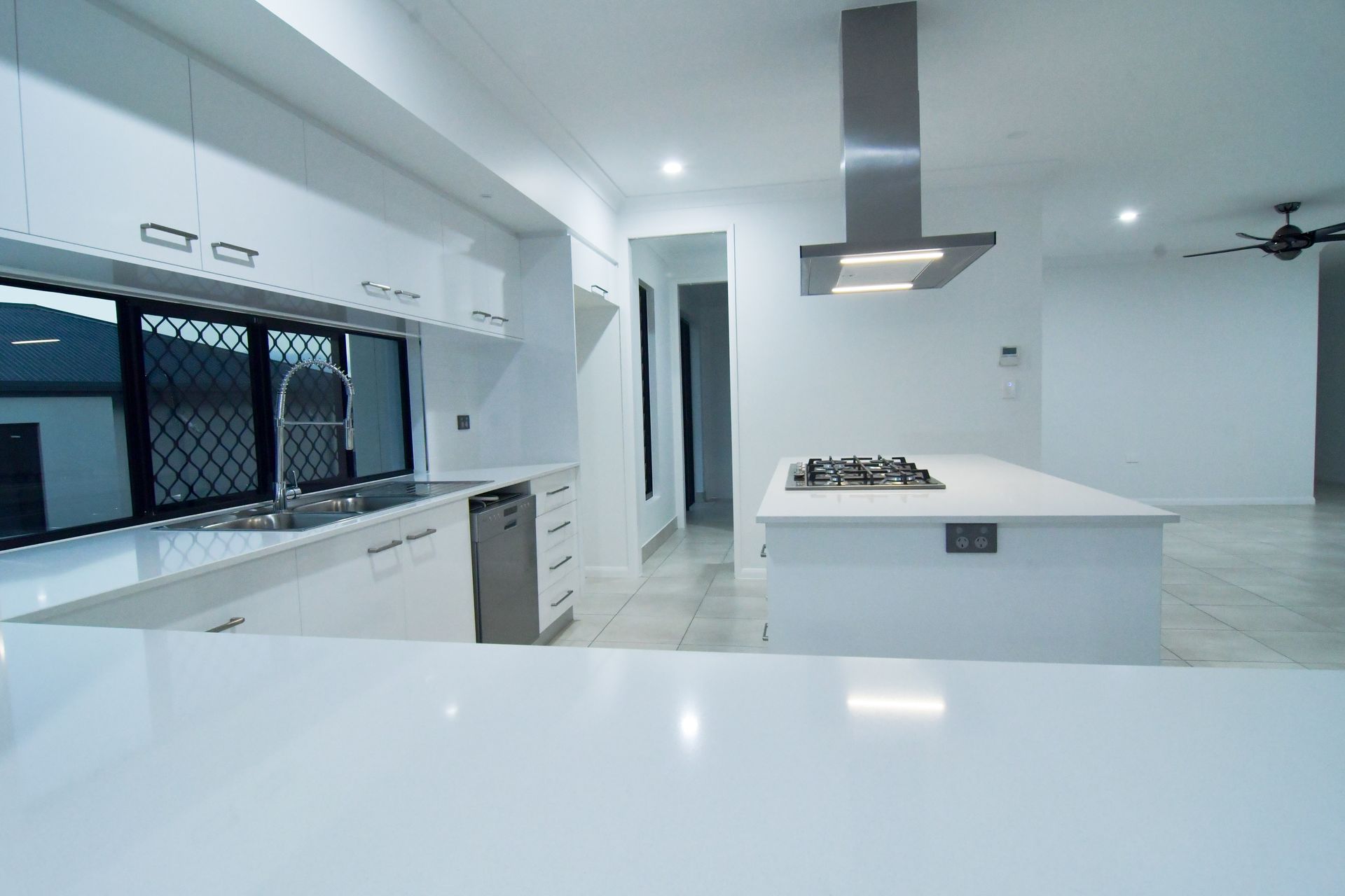 Modern White Kitchen With Island, and Stainless Steel Range Hood — B & C Cabinets in Mareeba, QLD