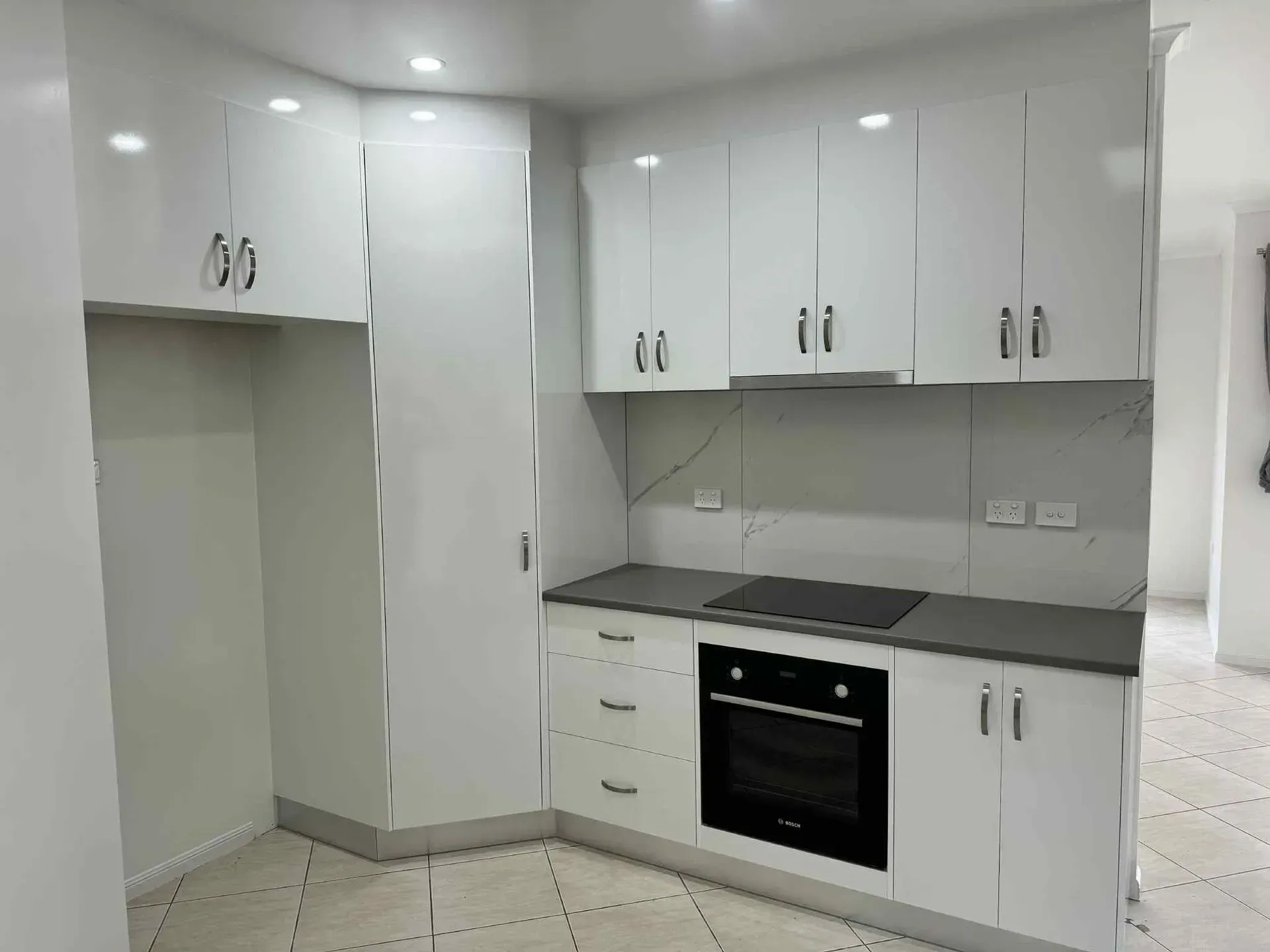White Kitchen With Cabinets, Stove, Oven, And Tiled Floor — B & C Cabinets in Mareeba, QLD