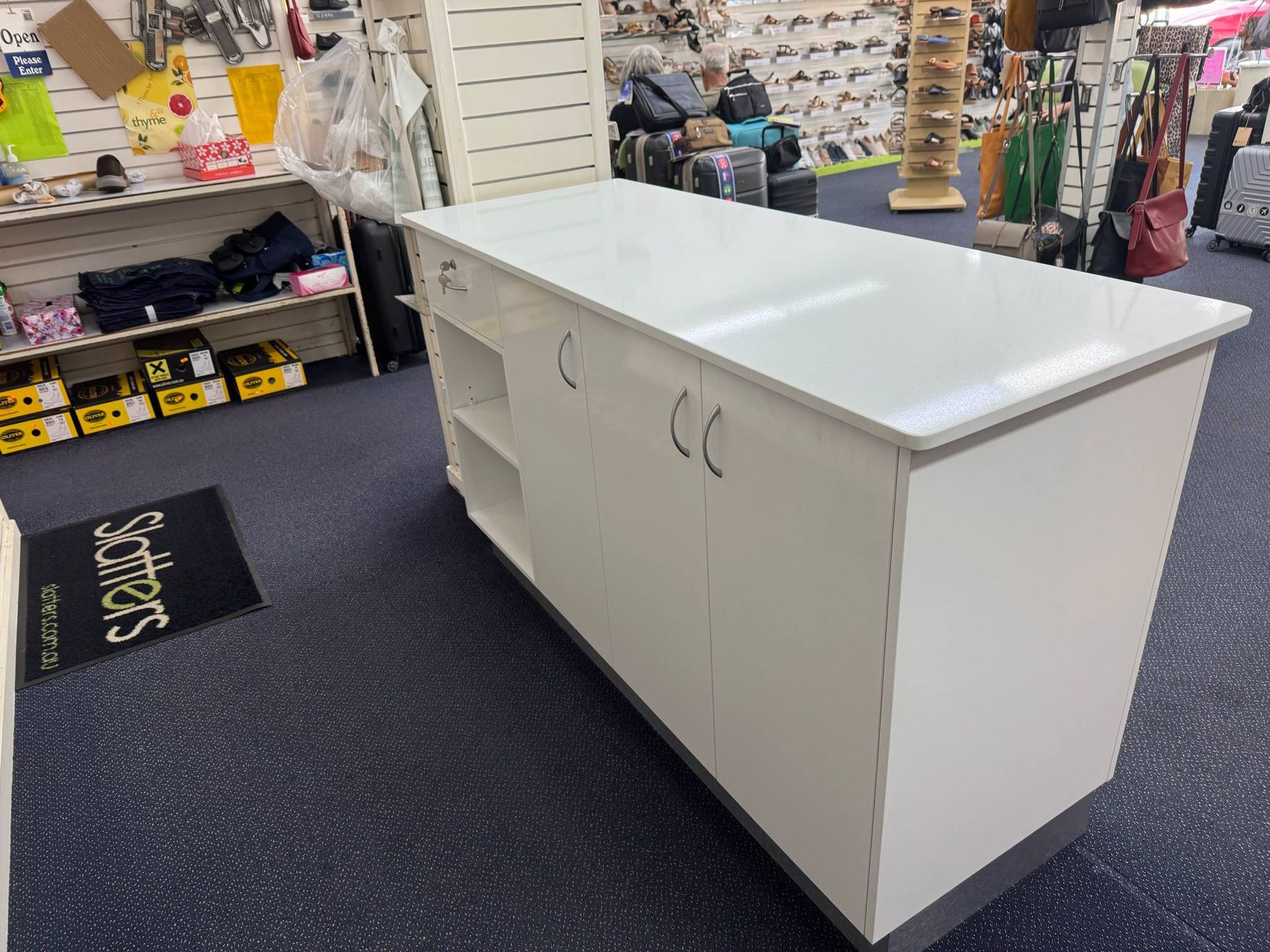White Rectangular Retail Counter With Shelves And Cabinets. Inside A Store With Blue Carpet — B & C Cabinets in Mareeba, QLD