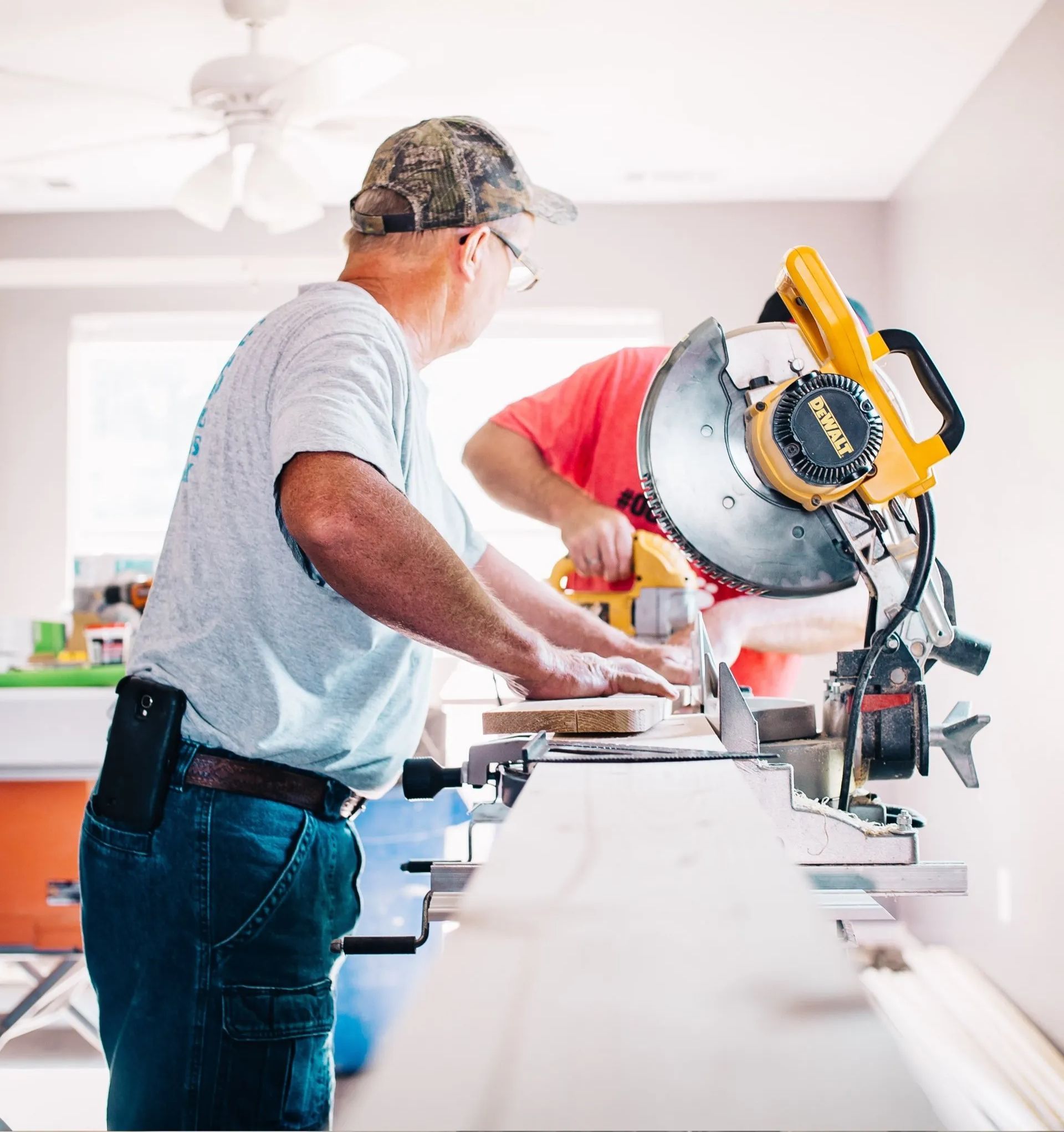 Craftsman cutting a board with a table saw in a kitchen