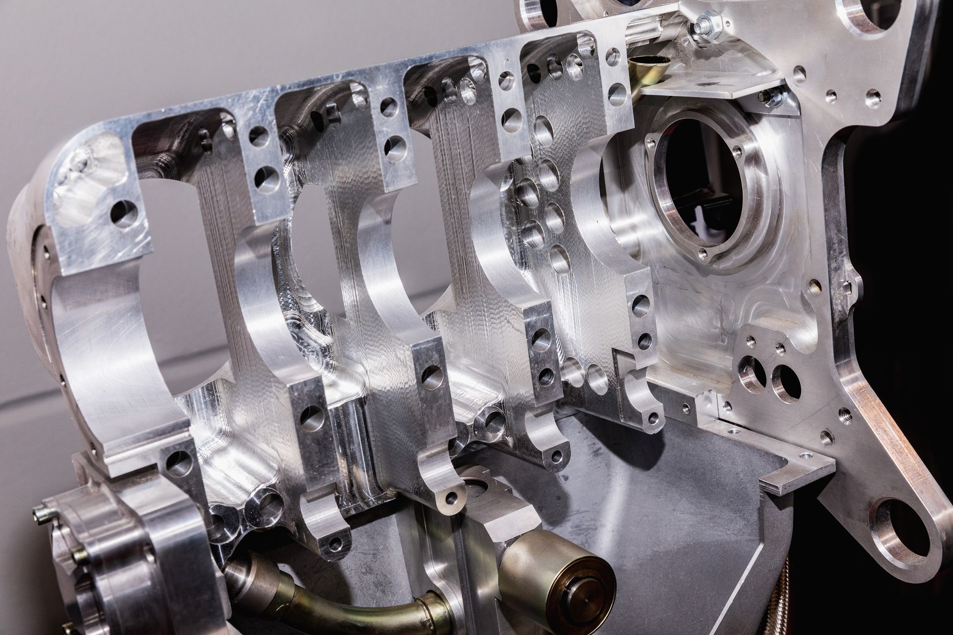 Close-up of a machined, aluminum internal combustion engine block showing the main bearing saddles.