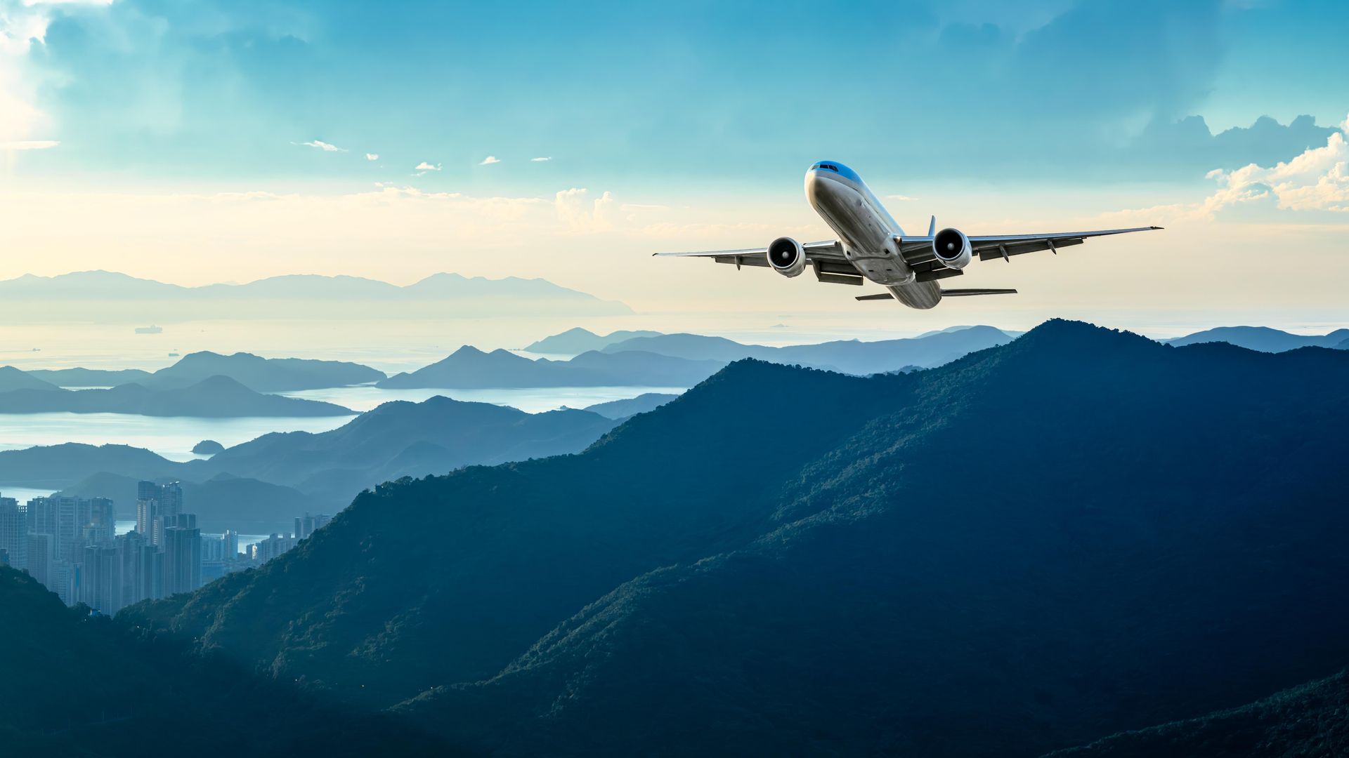 A small propeller plane is flying through a cloudy blue sky.