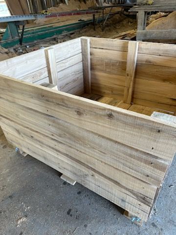 A large wooden box is sitting on top of a pallet.
