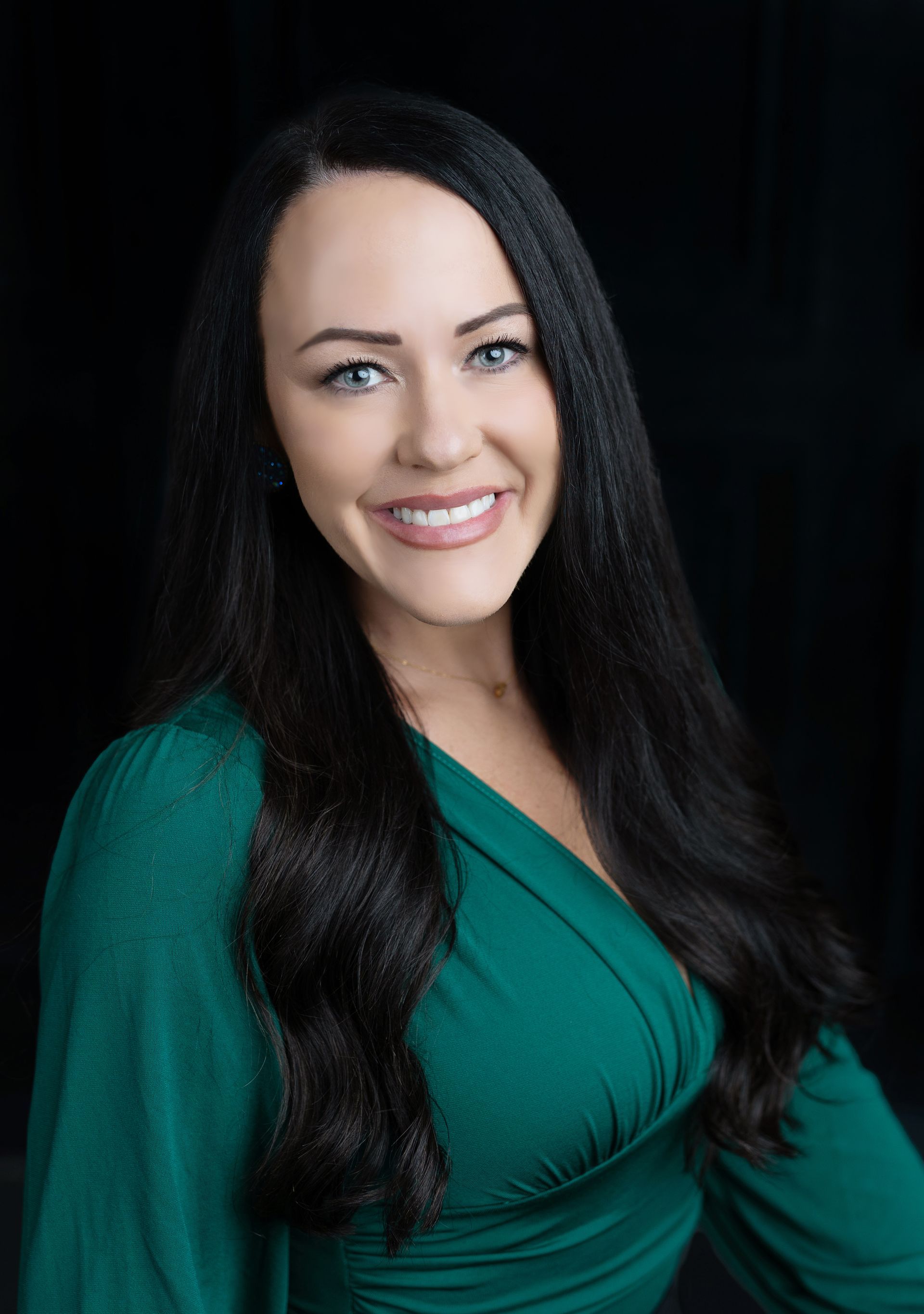 The woman is wearing a green shirt and smiling for the camera.