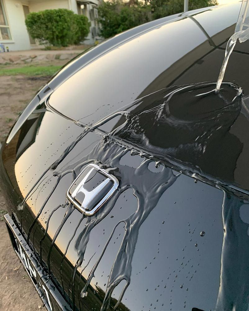 A Black Honda Car is Parked in Front of a House — Best Car Detailing in Vincent, QLD