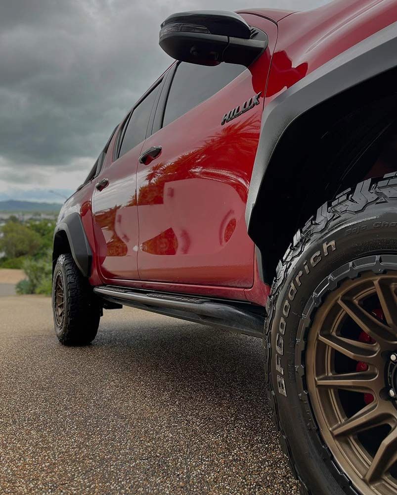 A Red Truck With Bfgoodrich Tyres is Parked on the Side of the Road — Best Car Detailing in Vincent, QLD