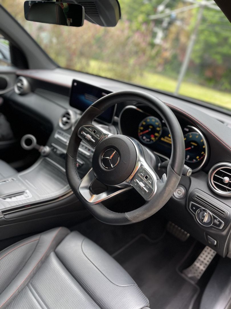 A White Sports Car is Parked in the Grass in Front of a House — Best Car Detailing in Vincent, QLD