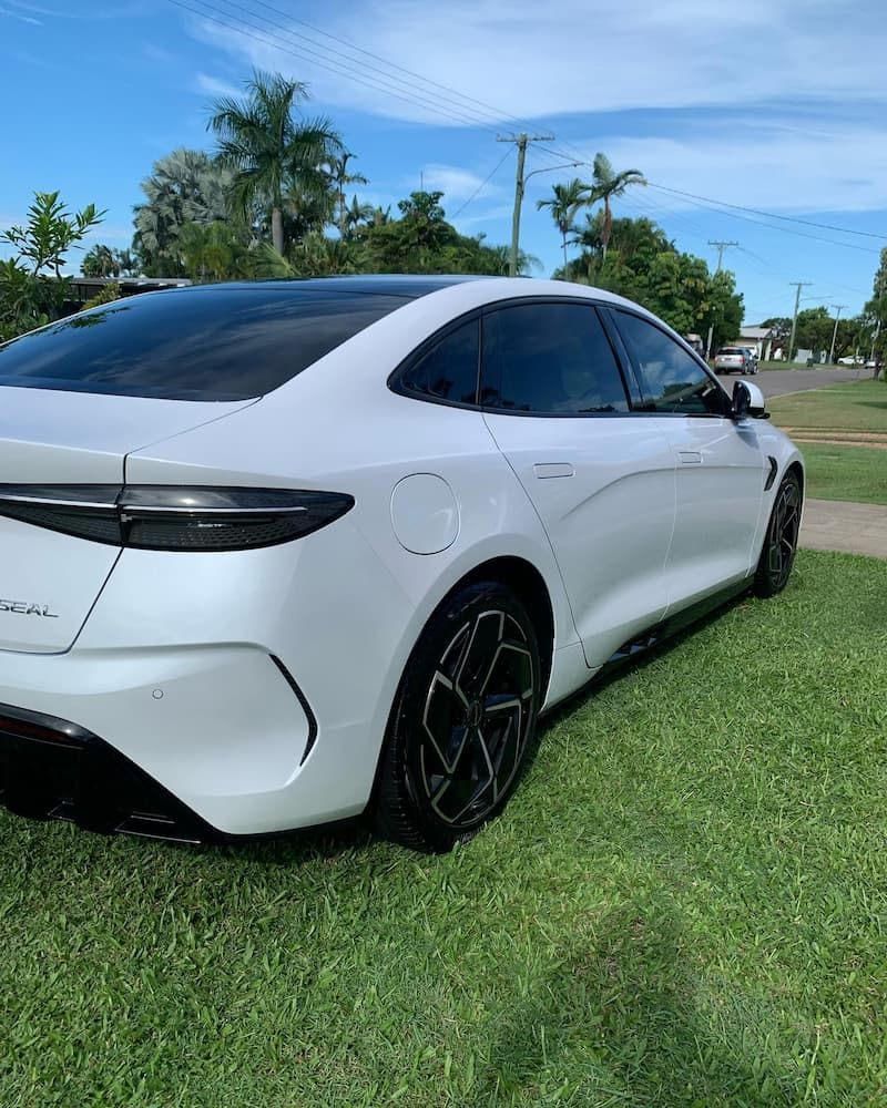 A White Car is Parked on the Grass — Best Car Detailing in Vincent, QLD