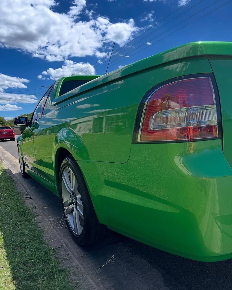 A Green Pickup Truck is Parked on the Side of the Road — Best Car Detailing in Vincent, QLD