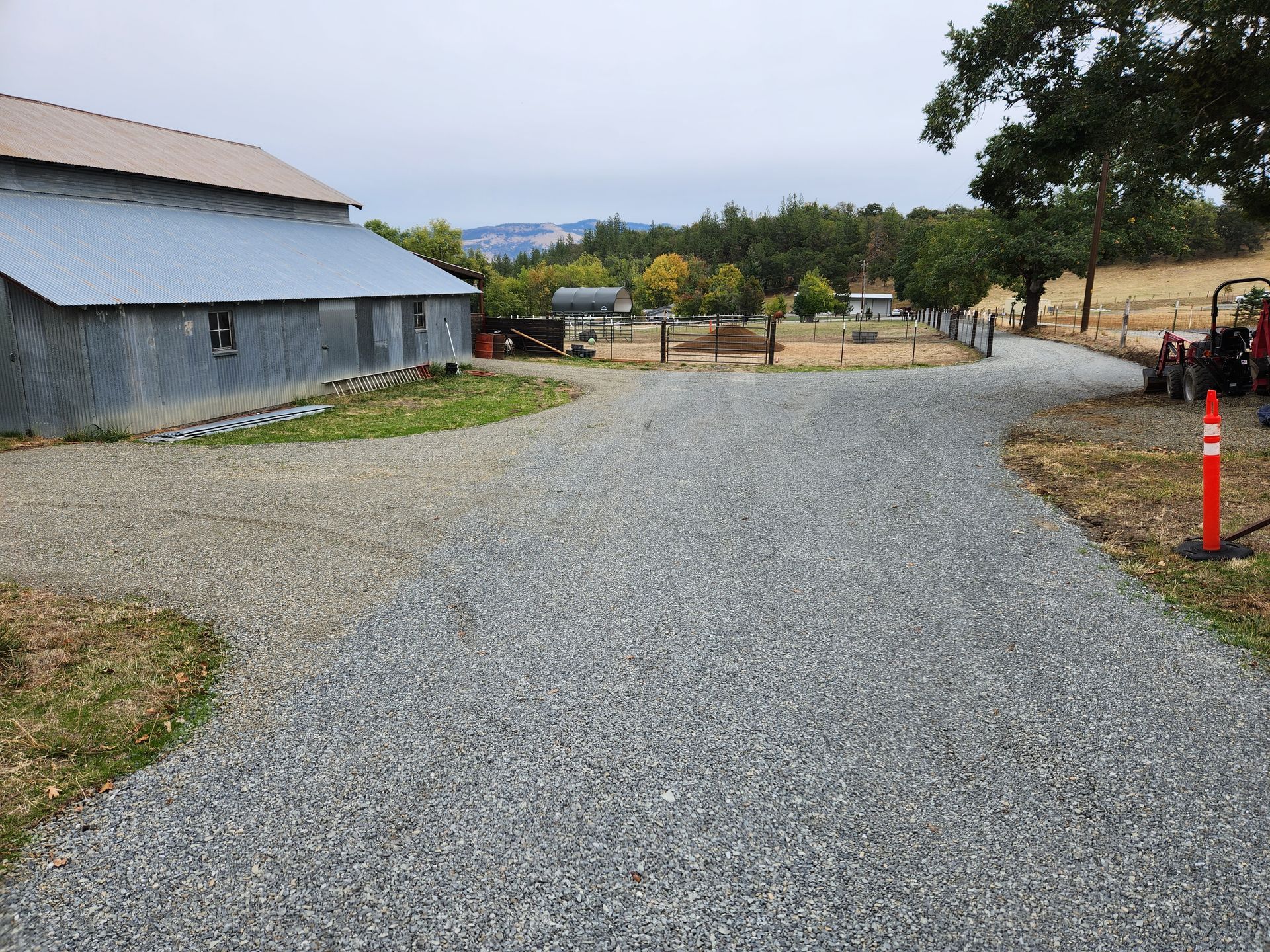 Gravel driveway being graded and compacted by an excavator in Southern Oregon