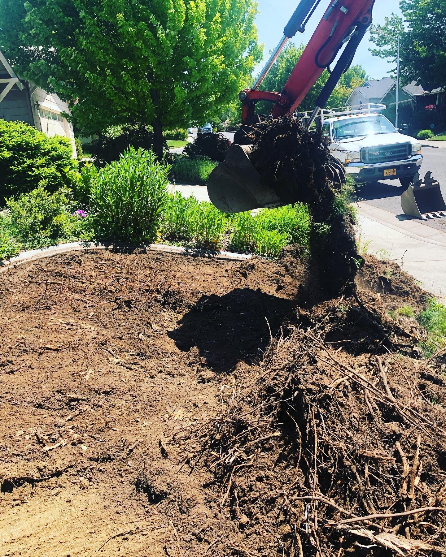 A large pile of dirt is being excavated by a backhoe.