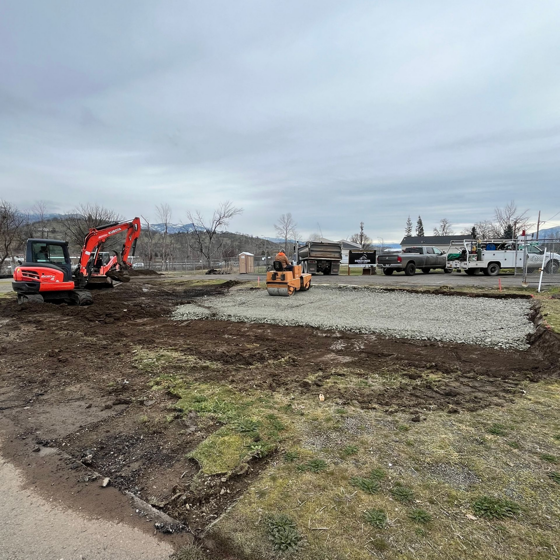Excavator grading a level house pad for a new home foundation in Southern Oregon