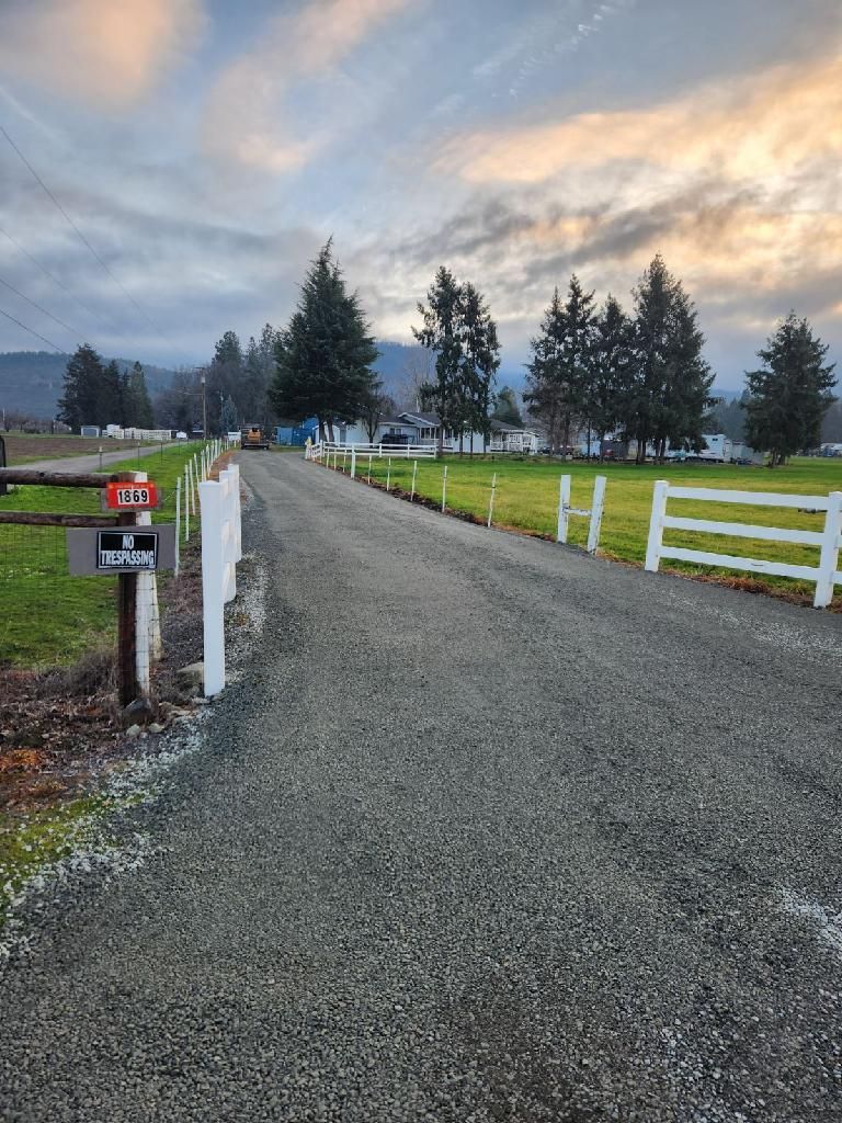 Gravel driveway being graded and compacted by an excavator in Medford Oregon