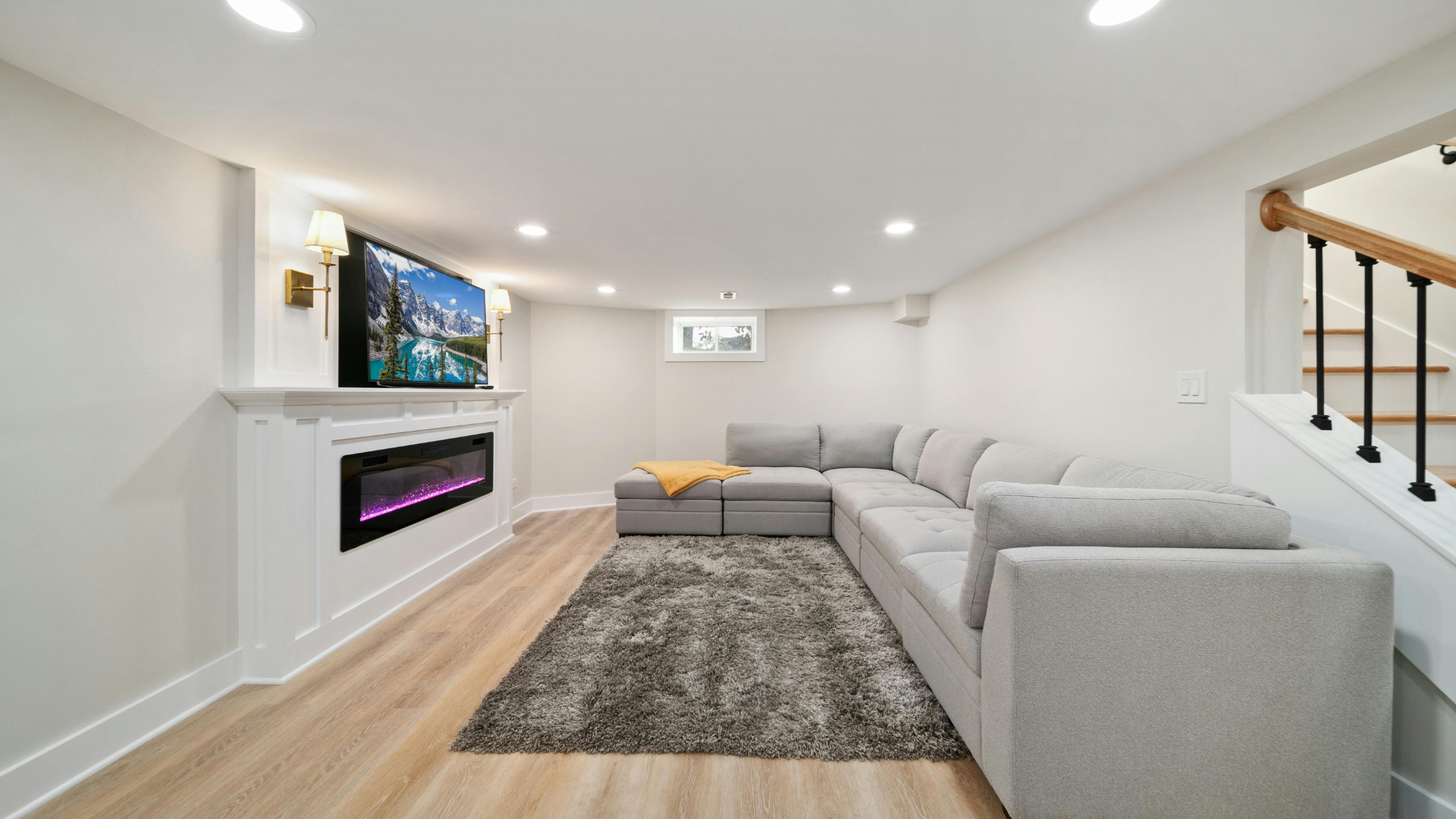 A living room with a couch , fireplace and television.