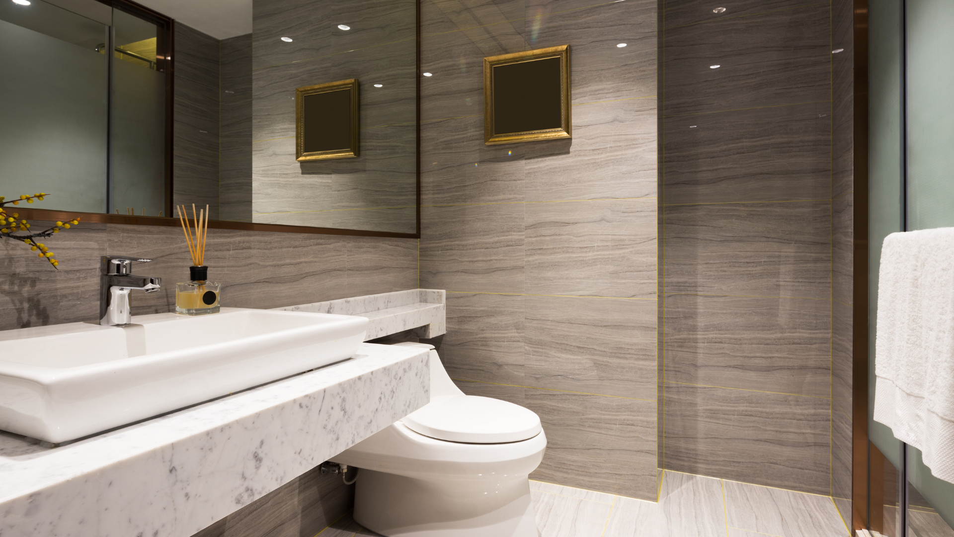 A bathroom with a toilet , sink , mirror and walk in shower.