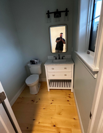 A bathroom with a toilet a sink and a mirror