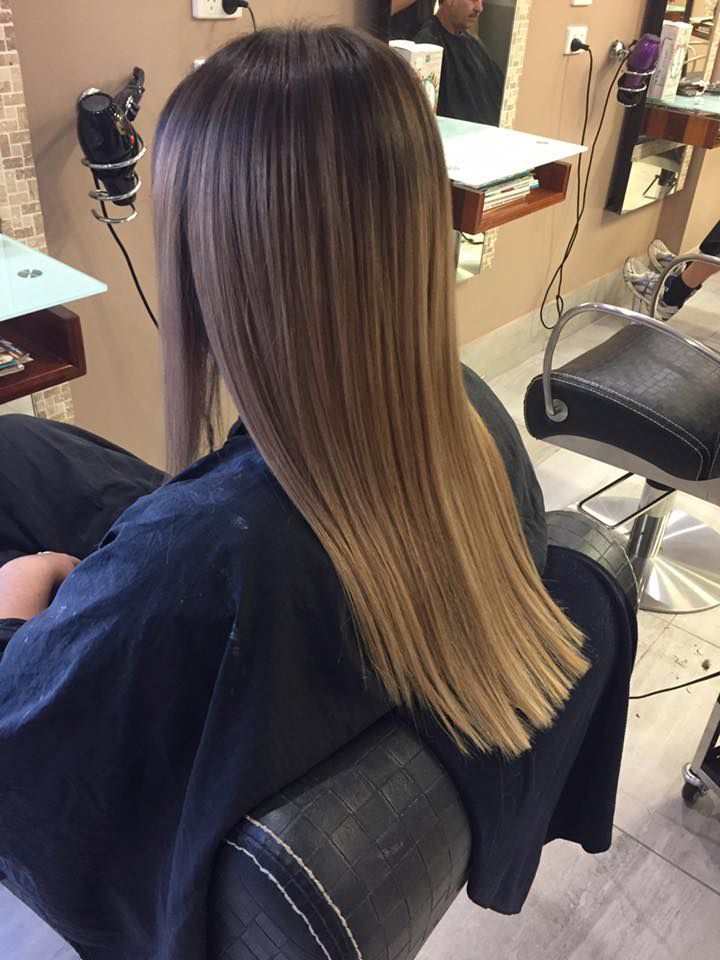 A Woman With Long Hair is Sitting in a Chair at a Hair Salon — Instyle Hair on B in Berserker, QLD