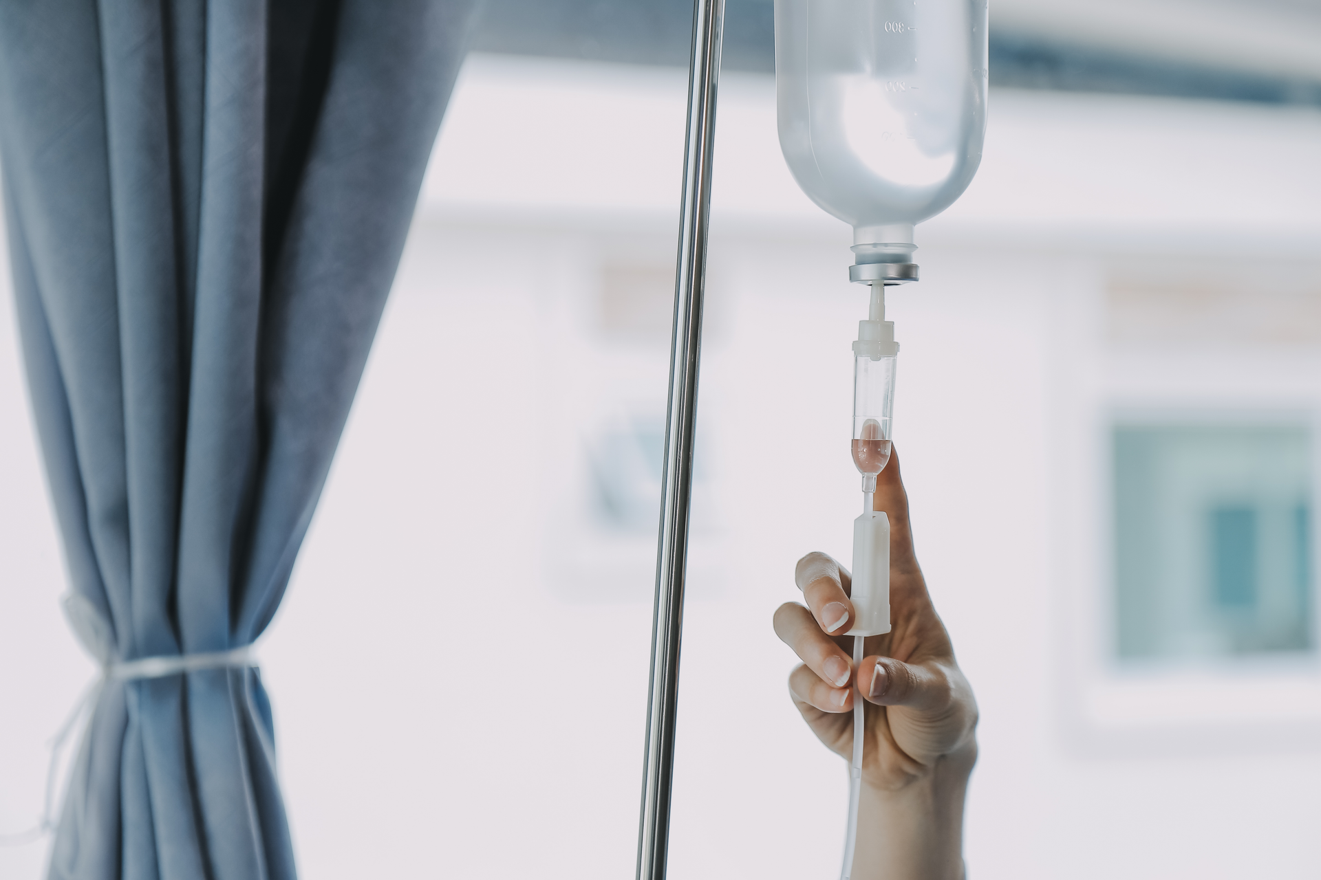 A person is holding an iv drip in their hand.