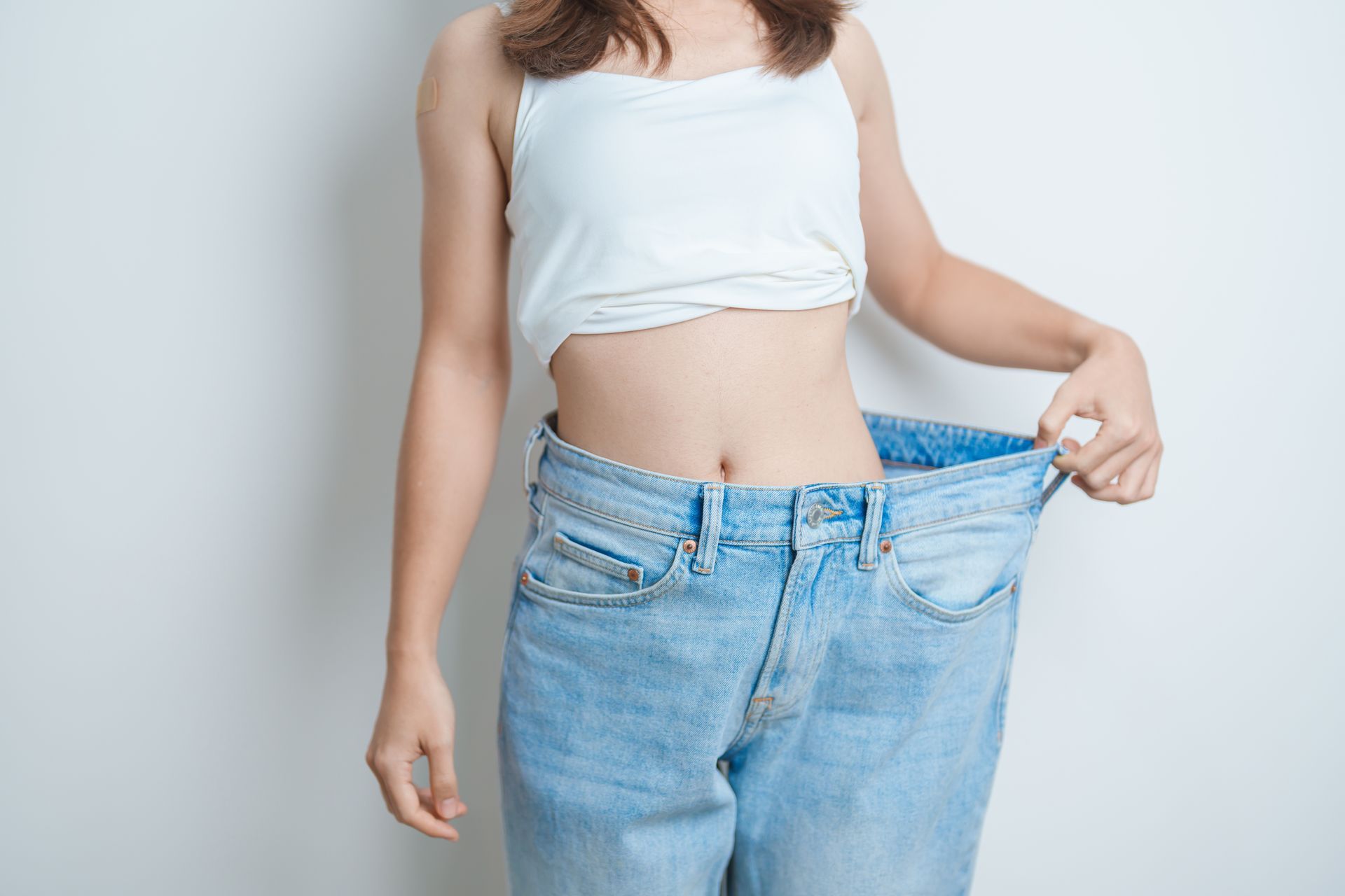 A woman is wearing a pair of very large jeans.