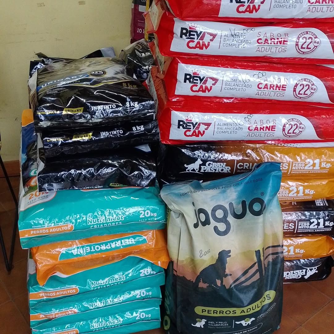 Montones de bolsas de comida para perros de varios colores, incluyendo rojo, naranja, negro y turquesa.