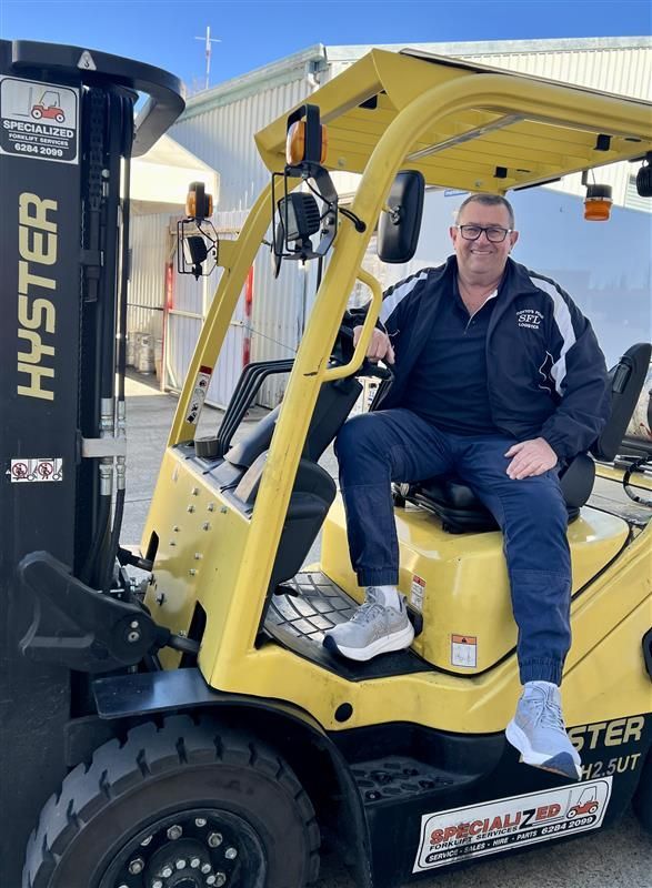 Man Sitting On A Yello Forklift— Scotto's Food Logistics in Mitchell, ACT