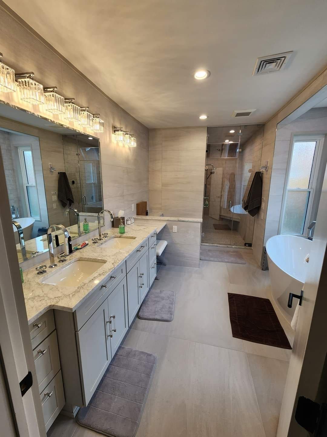 a bathroom with two sinks , a tub , and a mirror .