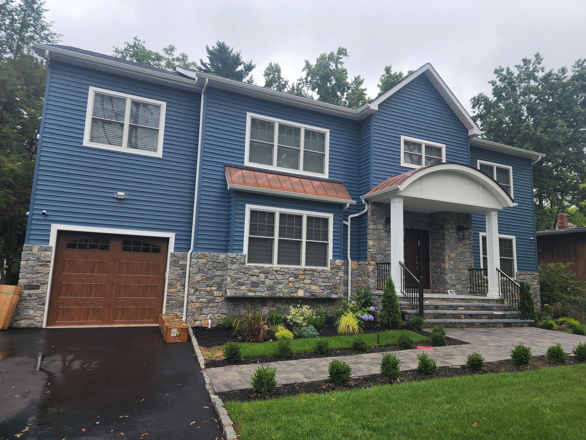 a large blue house with a brown garage door