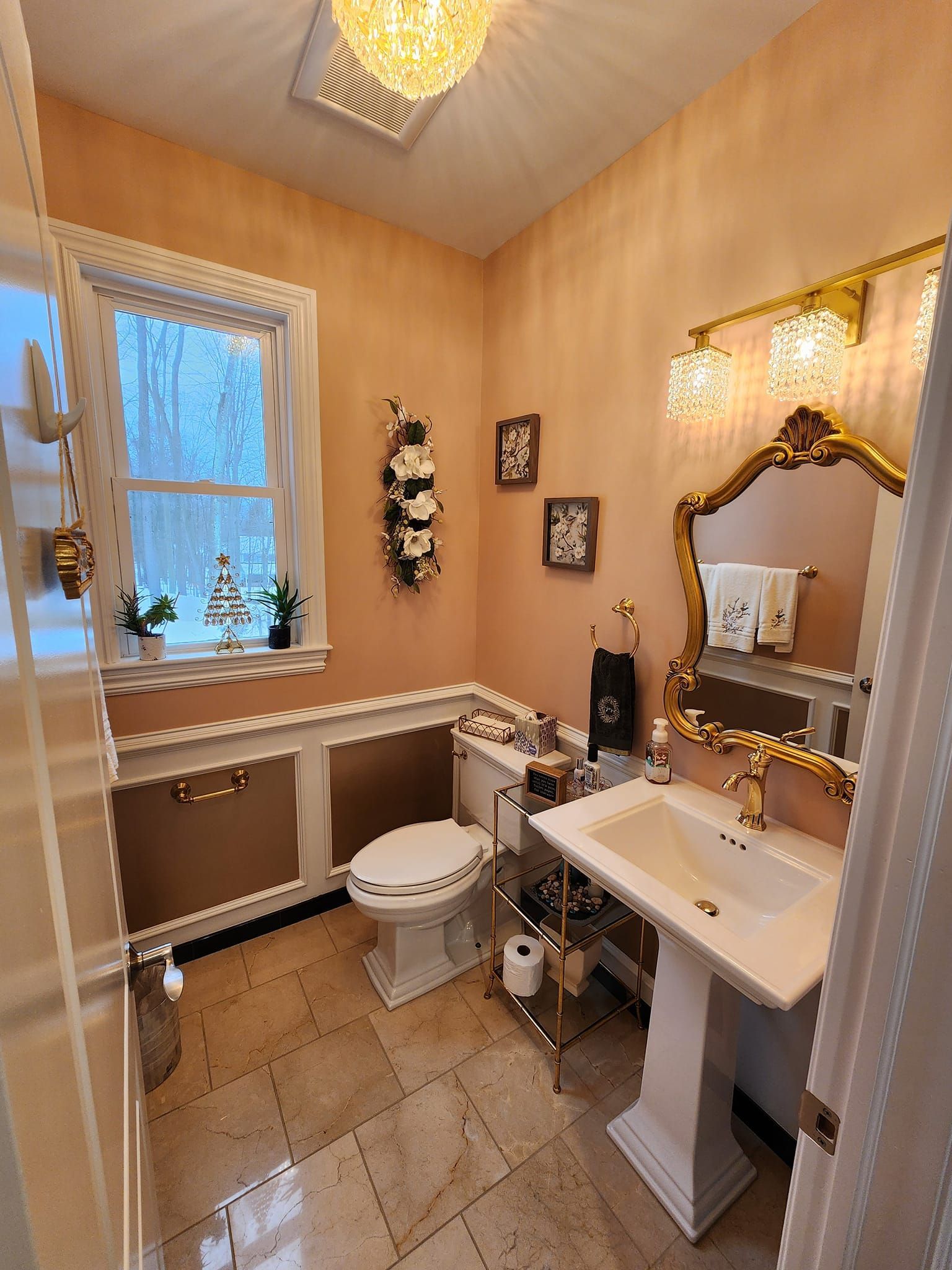 a bathroom with a toilet , sink , mirror and window .