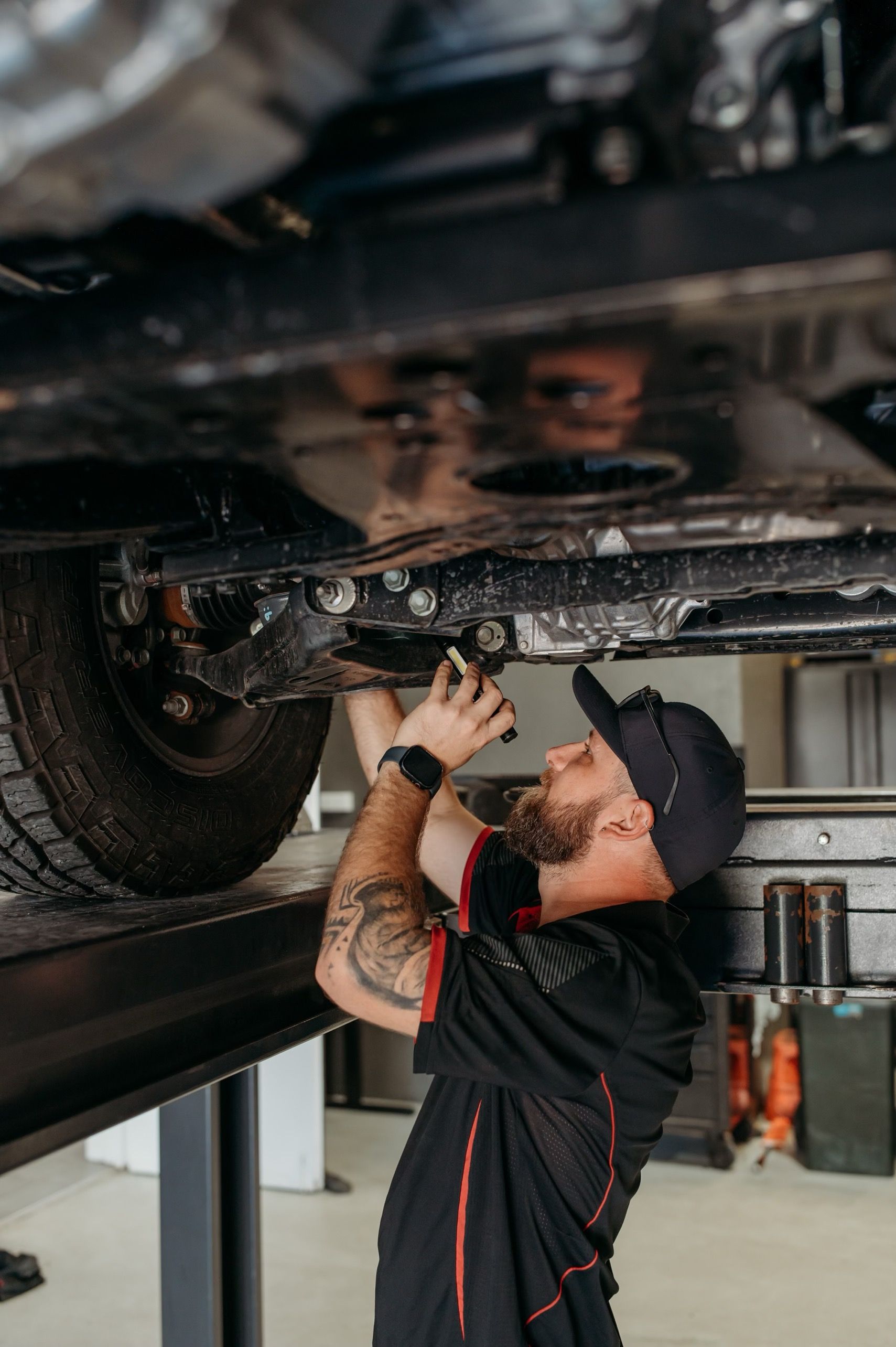 mechanic looking under the Car — Signature Mechanical In South Gladstone, QLD