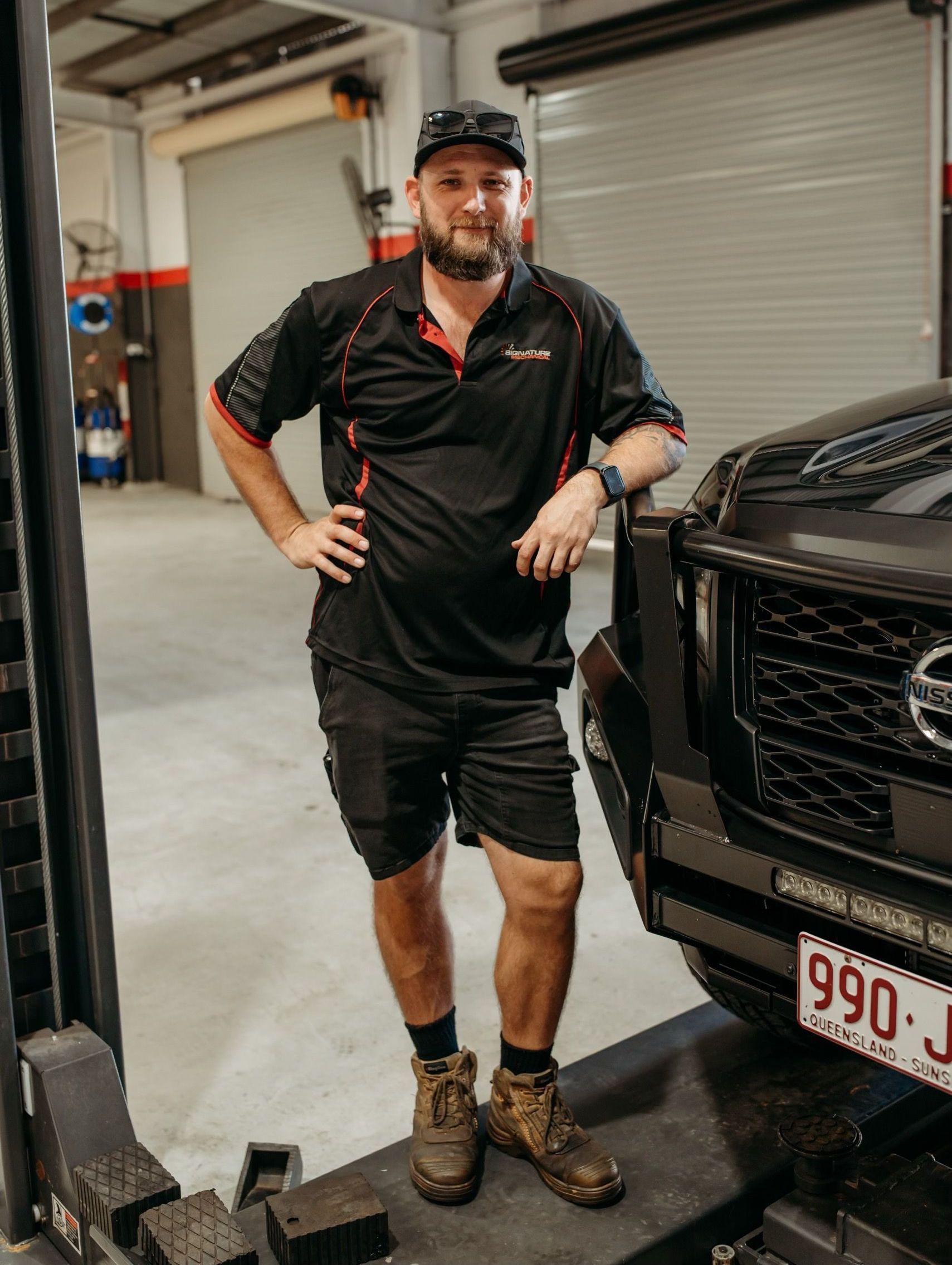 A Man Is Working On Engine Of A Car — Signature Mechanical In South Gladstone, QLD