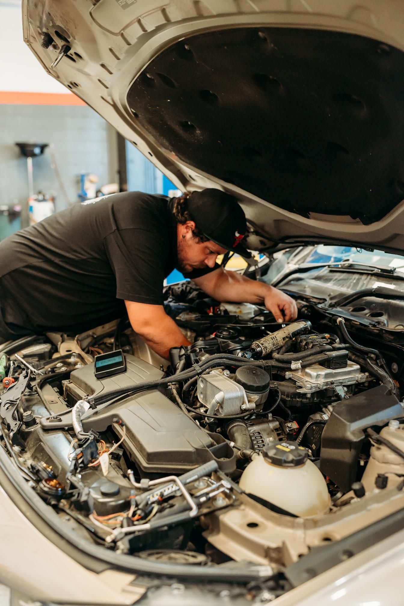 A Man Is Working On A Car In A Garage — Signature Mechanical In South Gladstone, QLD