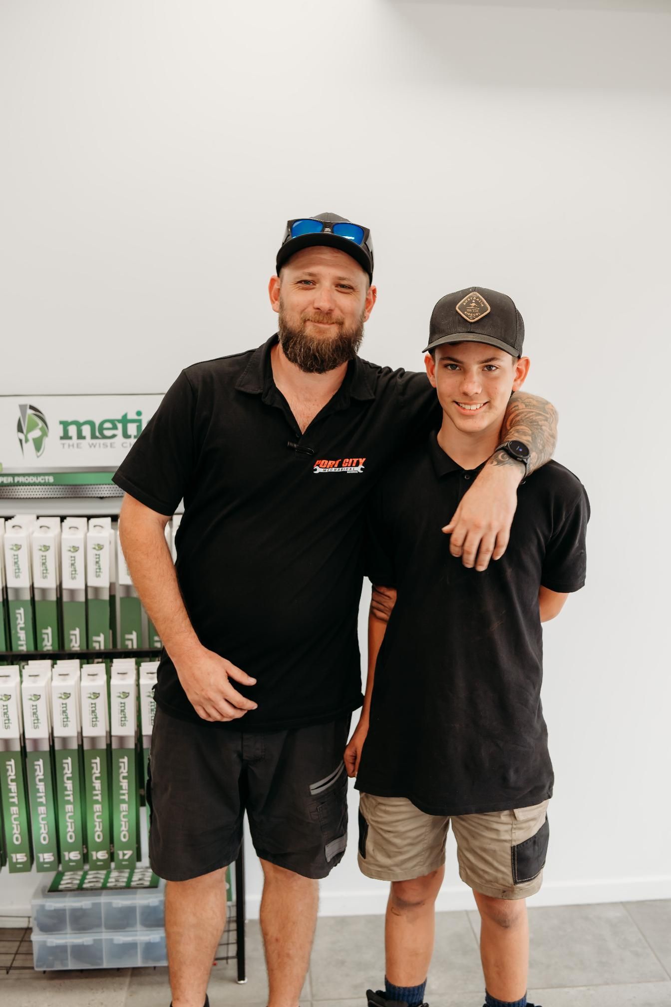 A Man in a mechanical outfit has his hand around the apprentice — Signature Mechanical In South Gladstone, QLD