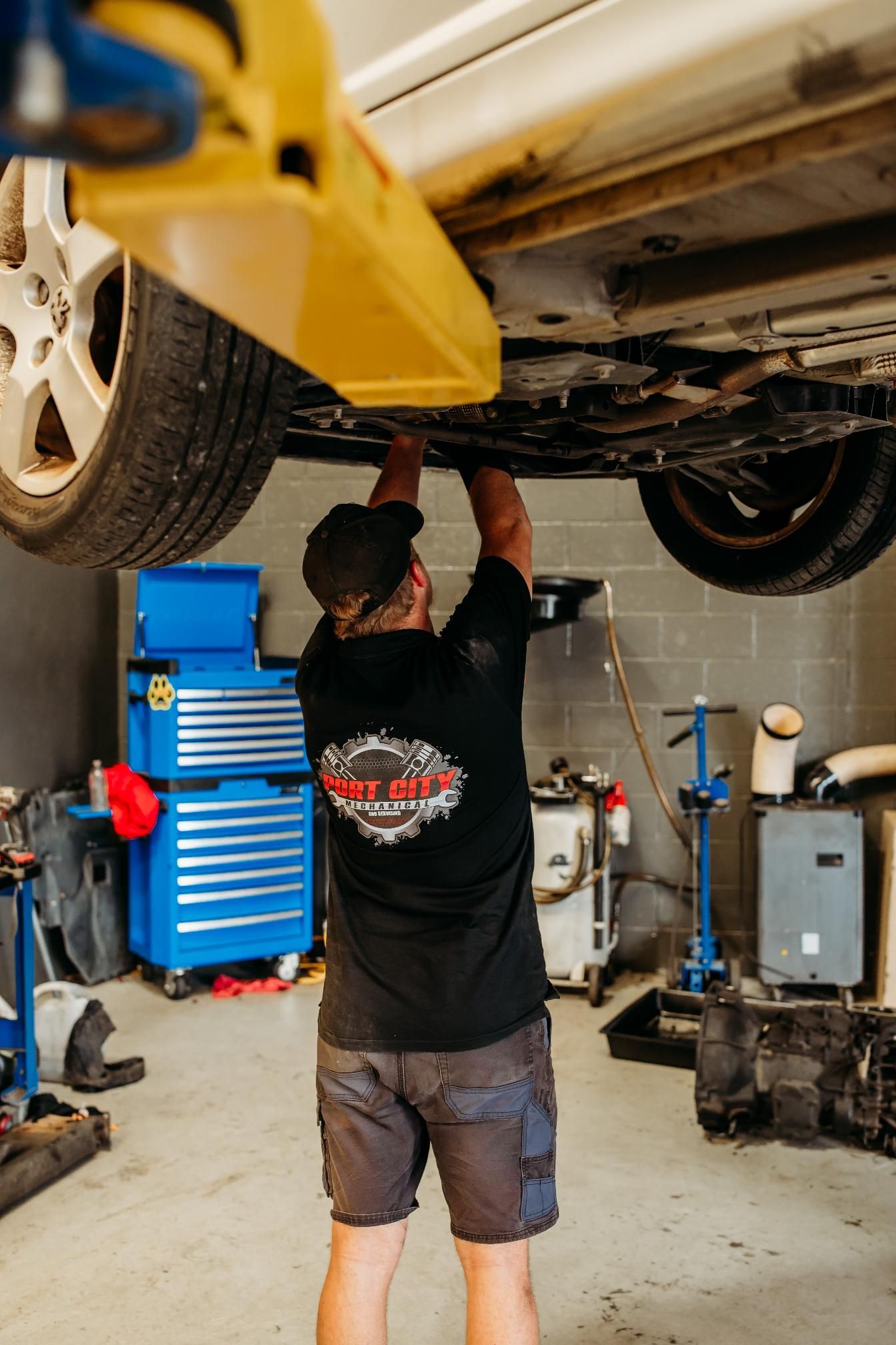 mechanic looking under the Car — Signature Mechanical In South Gladstone, QLD