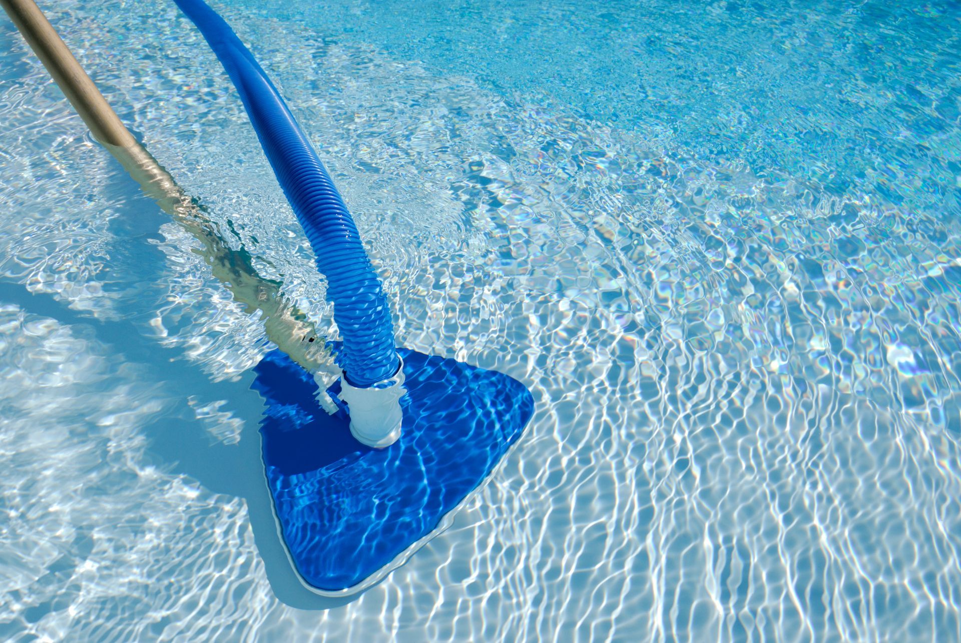 A Blue Vacuum Cleaner Is Being Used to Clean a Swimming Pool - Provo UT - Spa Doctor